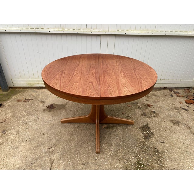 Beautiful round extendable dining table in teak and teak veneer 1970s edition This table features an integrated butterfly...