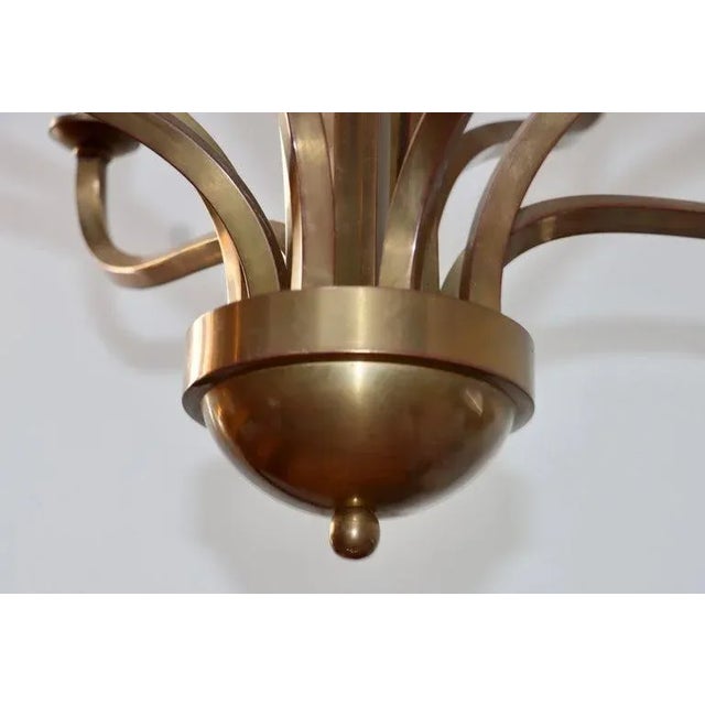 Large 1970s patinated brass twelve arm chandelier attributed to Hart Associates, In vintage original condition with...