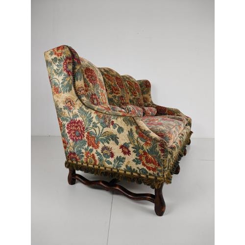 An elegant Os de Mouton sofa , upholstered in tapestry, with beautiful flowing shapes and a finely carved walnut frame....