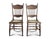 A pair of antique pressed back chairs with tooled leather seats. The spindle back dining chairs have a floral motif...