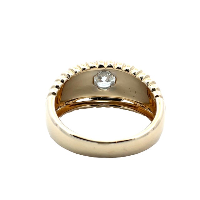 Bold two-tone 14K yellow and white gold band ring centered with a bezel-set round diamond totaling approx. 0.53 carats....