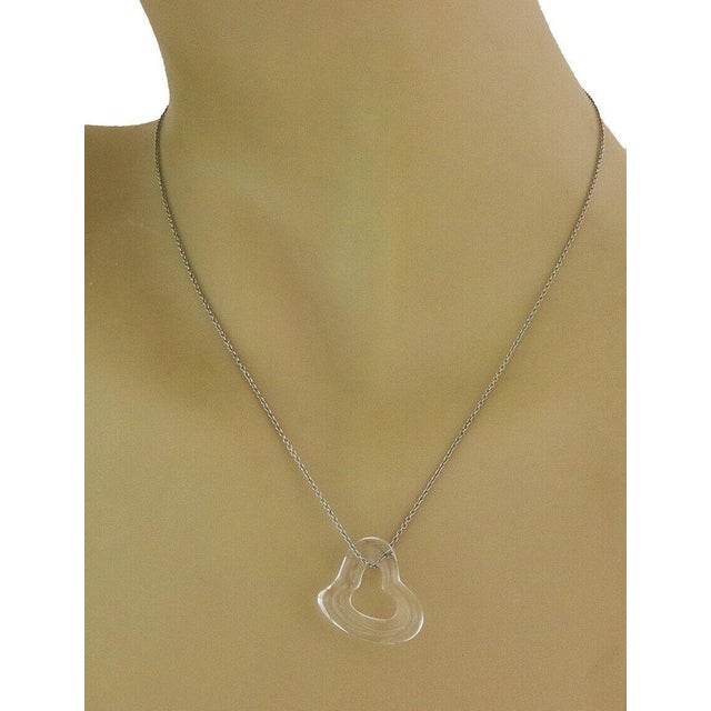 From Tiffany & Co. by designer Elsa Peretti from her Open Heart Collection, this authentic necklace features a colorless...