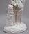 19th Century parian figure of a lady leaning on a column, here she is dressed in typical fashion of her time, holding what...