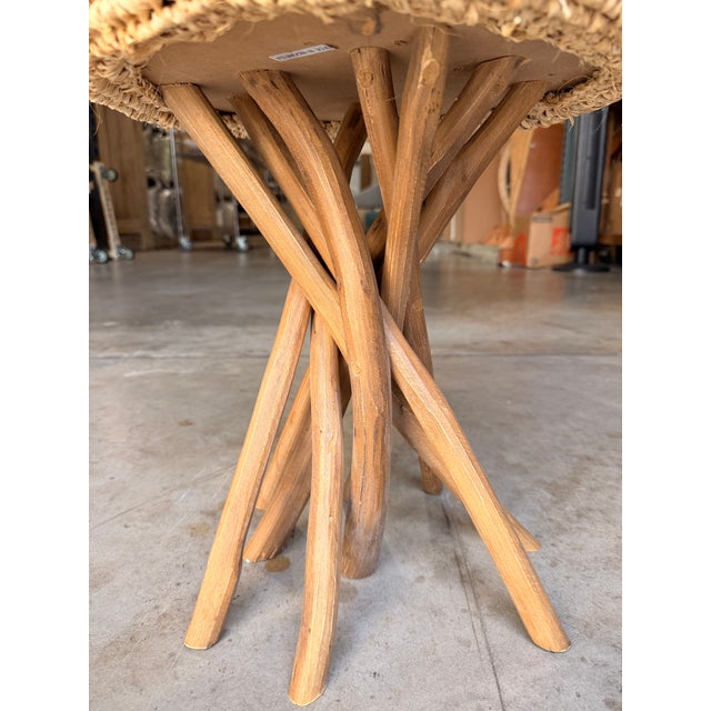 Contemporary coastal accent stool featuring a natural raffia seat paired with a sculptural solid teak base for an organic,...