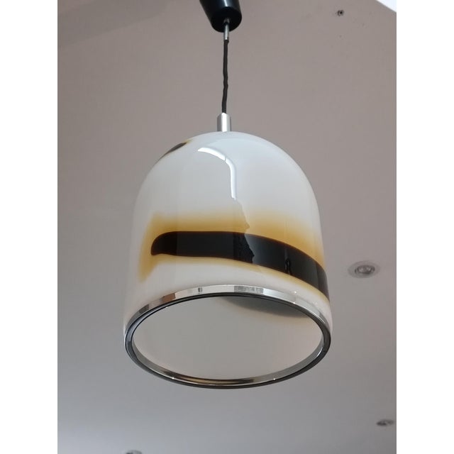 Beautiful pendant lamp. Italy, 1970s. Chrome-plated metal frame. It supports a magnificent thick Murano glass diffuser....