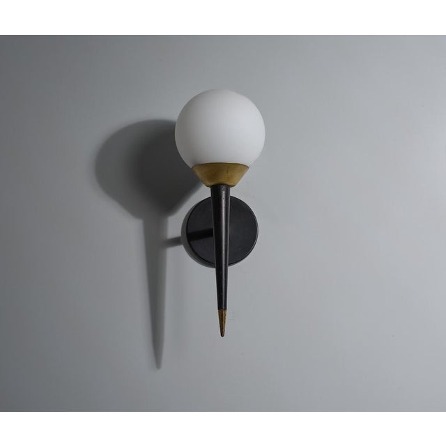 Offered here is an elegant Italian wall lamp from the 1950s, embodying the sleek and sophisticated design characteristic...