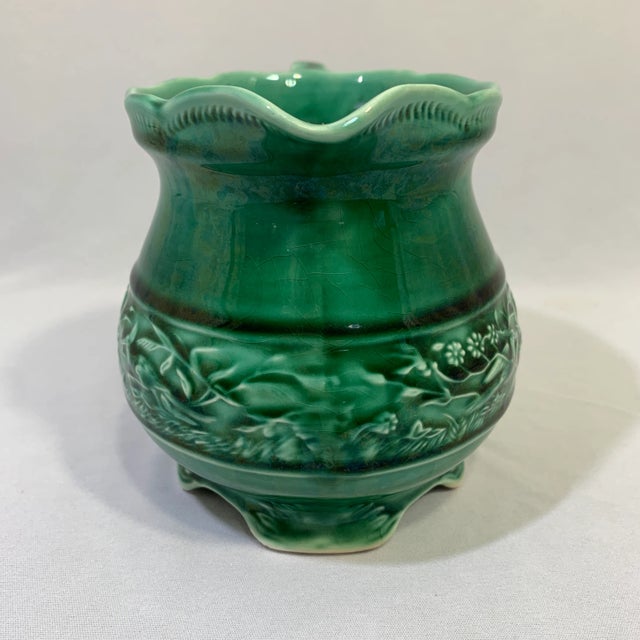 The pitcher design features a sturdy handle and bottom with four footings resembling early American pottery stamped USA....