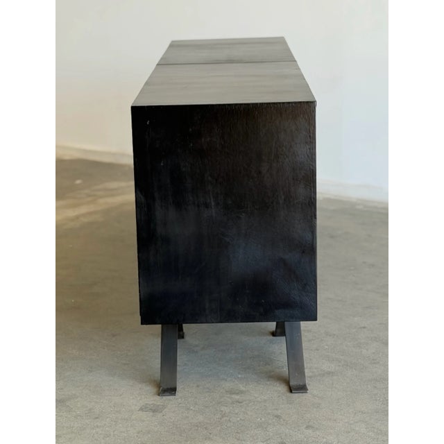 W84 D20 H33.75 Large 7ft credenza featuring a black leather wrapped case with four rosewood door panels. The solid brass...