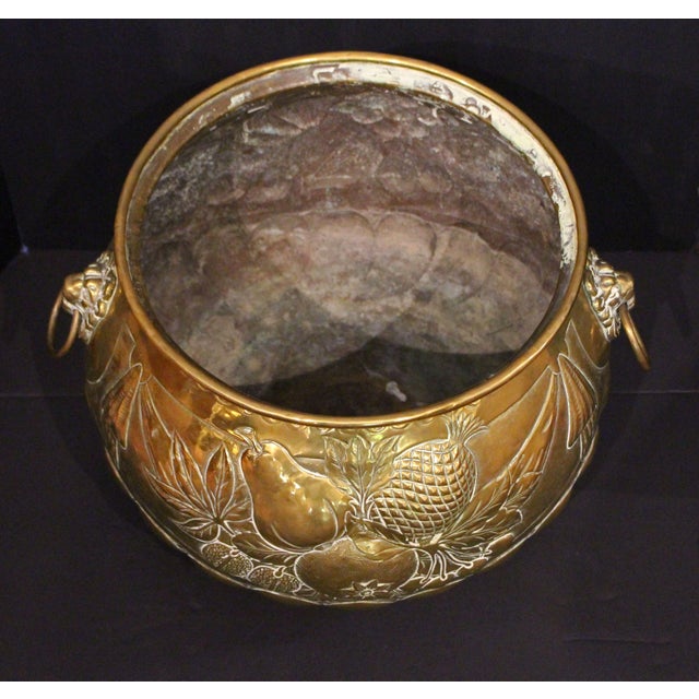 Circa 1860-80 circular repousse brass jardiniere, English. Grand, bold Rococo style. Massive lion mask handles. Decorated...