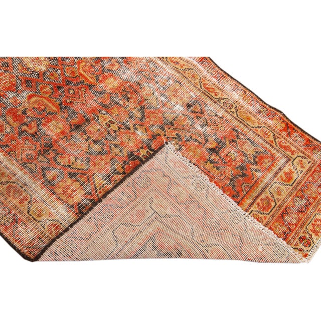 Beautiful vintage Persian distressed hand-knotted wool rug with an red color field. This piece has beige and brown accents...