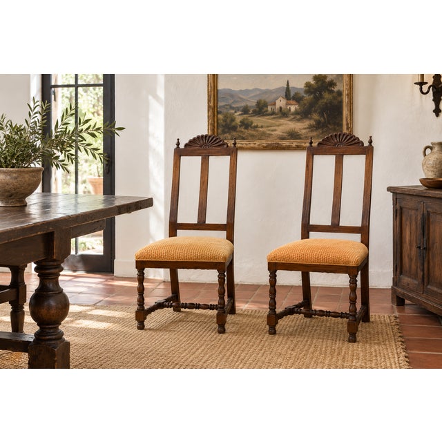 A carved shell crest rises between two turned finials on each of these chairs, above a pair of curved slats that give the...