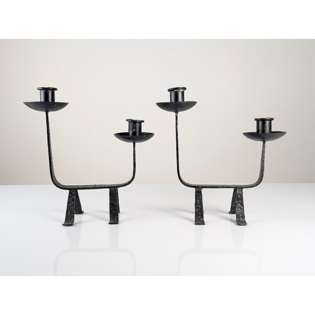 Pair of wrought iron candelabras made in Europe around 1950, featuring a sculptural design with clean lines and totemic...
