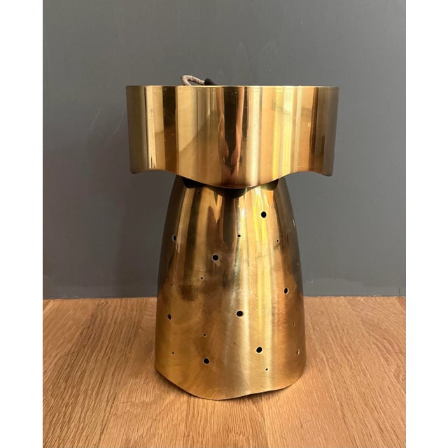 Vintage mid century flush mount light fixture in the style of Paavo Tynell. Fixture has perforated polished brass shade...