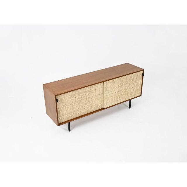 A two-door sliding sideboard lined with canvas, featuring leather handles and metal legs. One side has an adjustable...