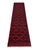 Repeating navy medallions create a bold geometric pattern across the rich red field of this tribal runner. Smaller motifs,...