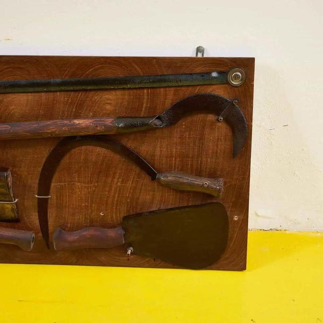 Item : This unique panel features a collection of antique tools, expertly arranged on a wooden base. Each tool tells a...