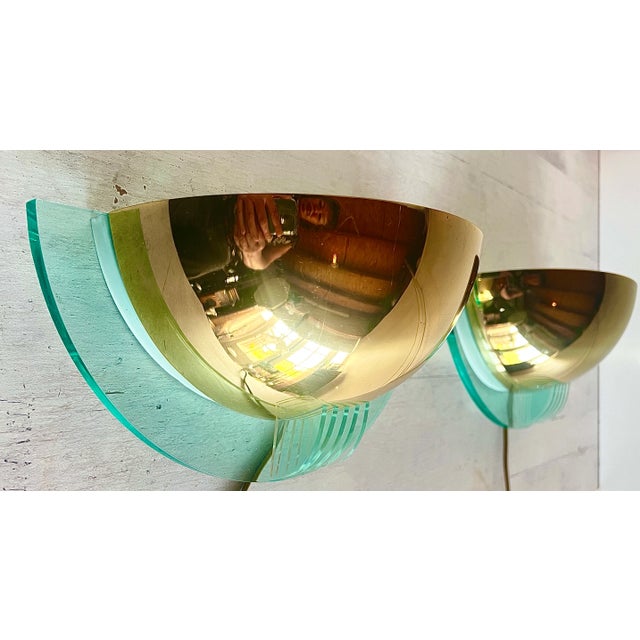 A set of wall lamps from the Postmodern period, 1980s. The lamps are made of gold-coloured brass and clear green...