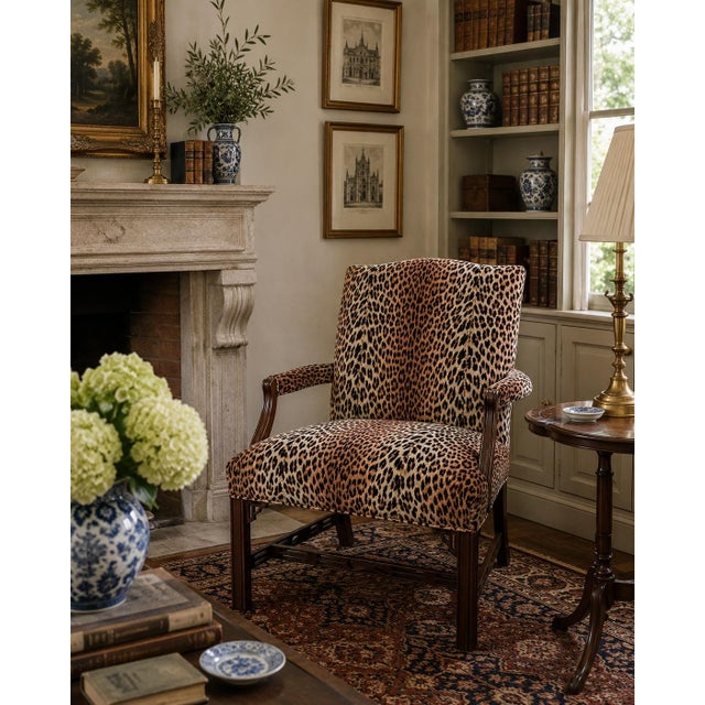 A handsome late 20th-century English Chippendale-style armchair crafted in richly toned mahogany and upholstered in a...
