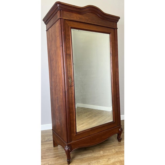 This elegant Antique French wardrobe showcases classic styling with a shaped cornice, beautifully figured walnut finish,...
