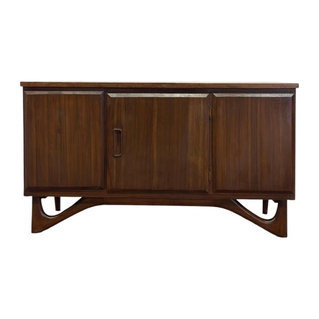 Vintage Low Laminate Top Walnut Petite Credenza has a durable, easy to clean surface and features splayed sculpted...