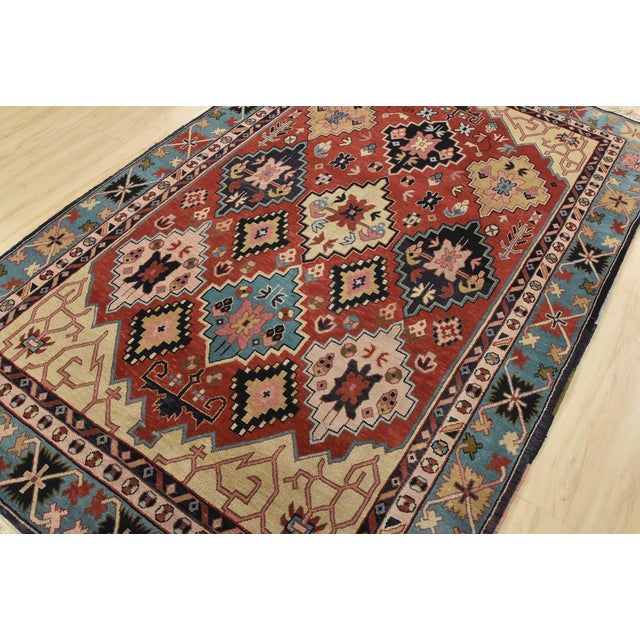 An authentic vintage tribal Heriz rug hand-knotted with fine wool on a cotton foundation. This rug features geometric...