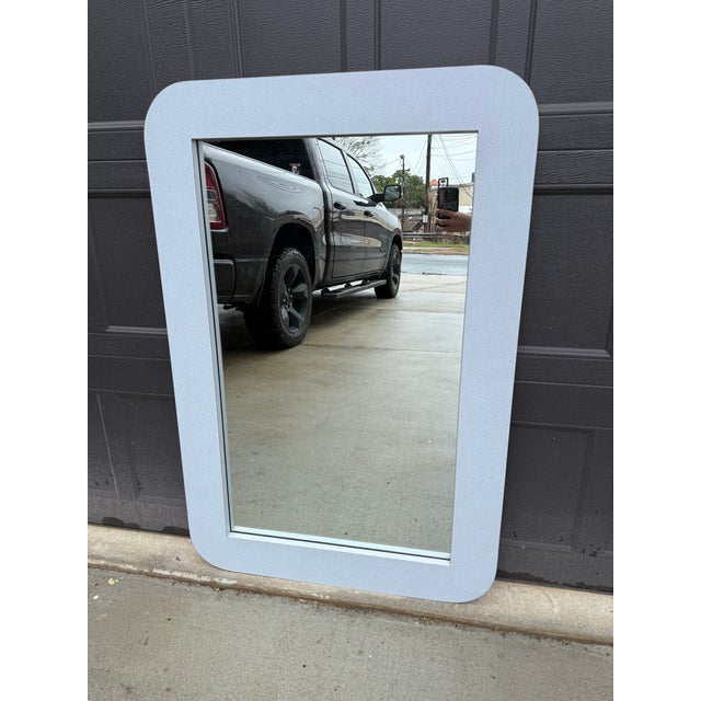 Authentic vintage 1980s wall mirror with a rounded rectangle silhouette and light blue laminate frame. This piece has that...