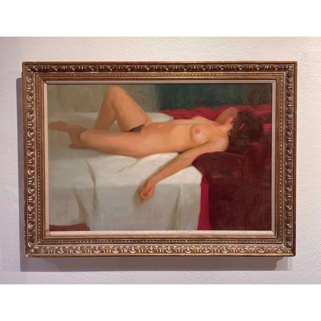 This oil painting captures a reclining nude figure, elegantly draped across a bed with a striking interplay of light and...