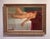 This oil painting captures a reclining nude figure, elegantly draped across a bed with a striking interplay of light and...