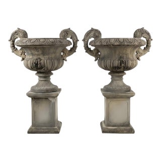 A Pair of Grand Neoclassical Cast Stone Urns on Paneled Pedestals For Sale