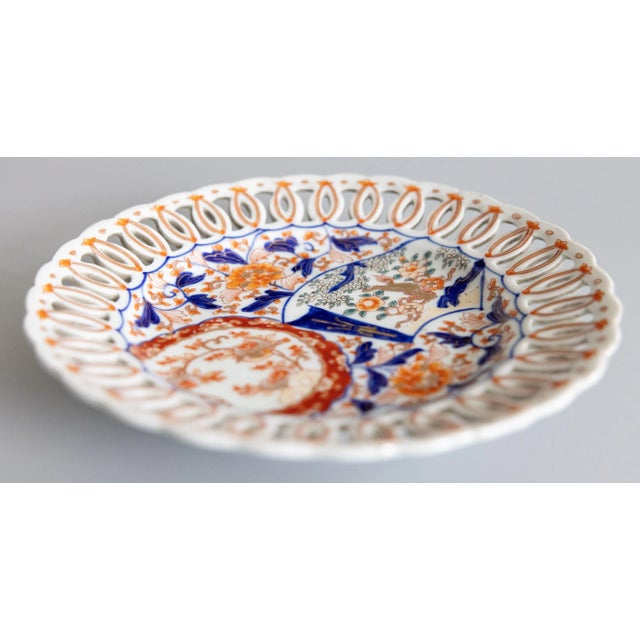 A wonderful 19th century antique Imari plate with a reticulated edge. Featuring vibrant oranges, blues, and green. The...