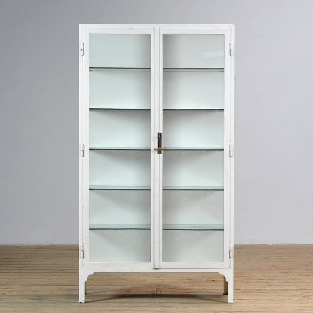 Medical cabinet from the 1930s, manufactured in Hungary. This characterful display cabinet is crafted from thick iron and...