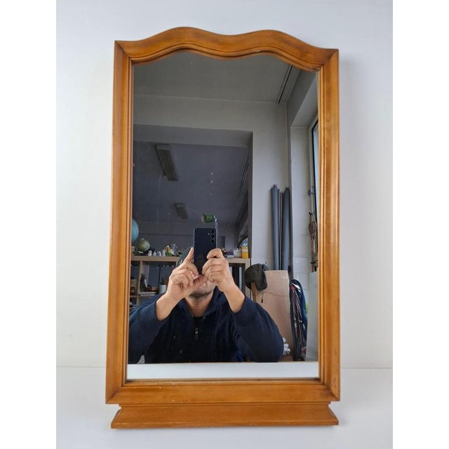 This mid-century mirror from 1960s Czechoslovakia features a sculpted walnut frame with gentle curves and a warm natural...