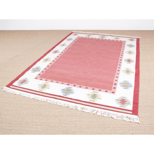 This Swedish Rolakan carpet in hand woven wool features geometric patterns.