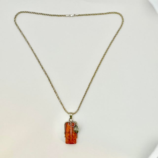 A lovely Italian Art Nouveau Sterling and Amber Pendant Necklace from the 1970s. The pendant features a large piece of...