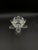 A decorative vintage crystal candle holder in the shape of a lotus flower, set on a tall, slender stem. The upper part of...