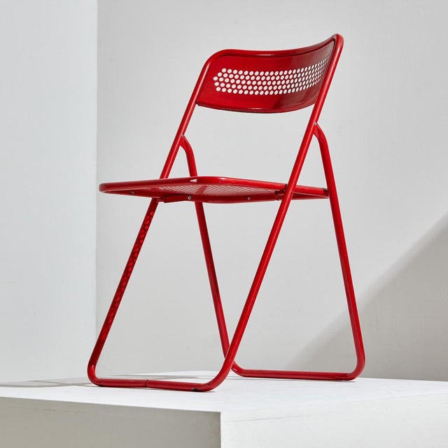 Metal foldable chair from the 1980s with some scratches, rust and wear on the metal frame.