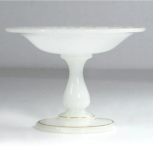 A decorative pater on the foot made of milk and white glass. It is decorated with a delicate, currently heavily faded...