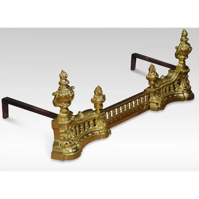 19th Century French gilt-brass fender, the extending pierced gallery surmounted to each end with vase finials above...