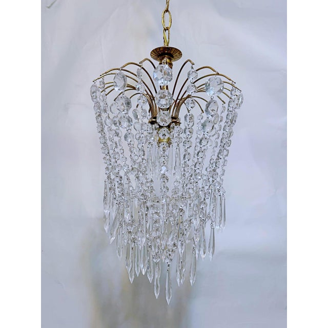 Parachute chandelier with brass wired dome, octagon chain, graduated chain and 30% leaded U-drop crystals. It has an...