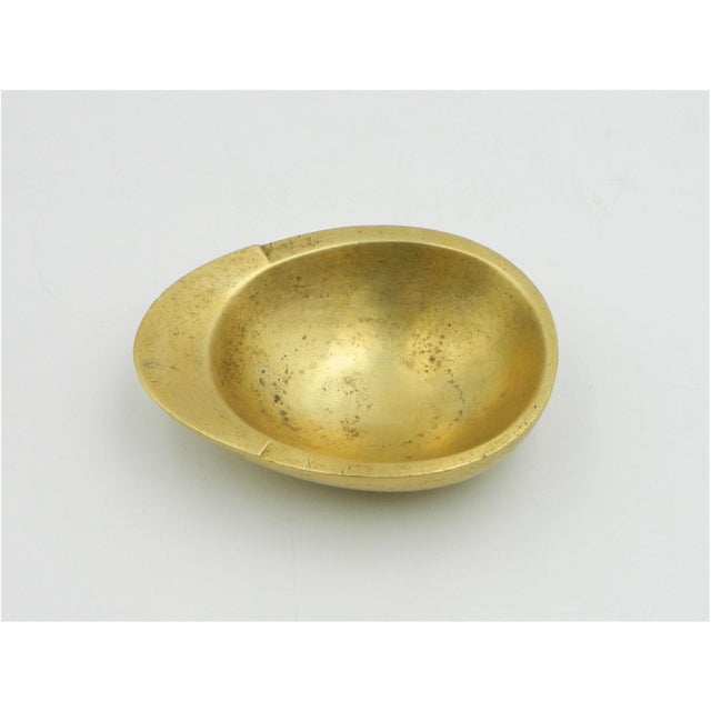 Ashtray model 3562 from the Carl Auböck workshop in Vienna. This bowl is made of solid brass with a slight raised section...