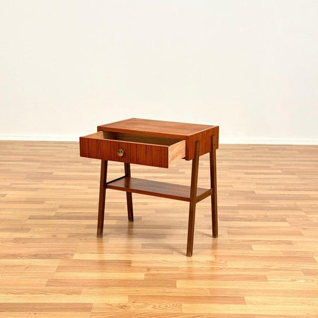 Side table was manufactured in Sweden in the 1950s-60s. It is made of teak veneer on top surface and solid beech wood on...