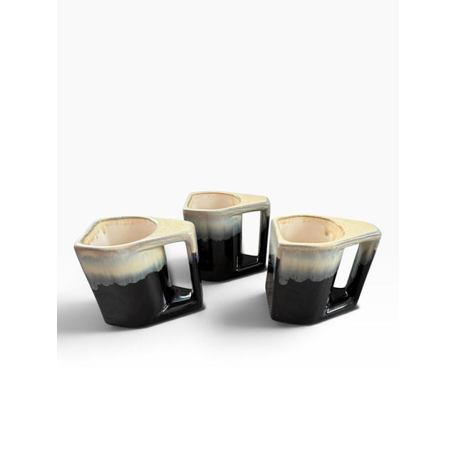Striking set of three vintage geometric stoneware mugs featuring a distinctive sculptural form with integrated rectangular...