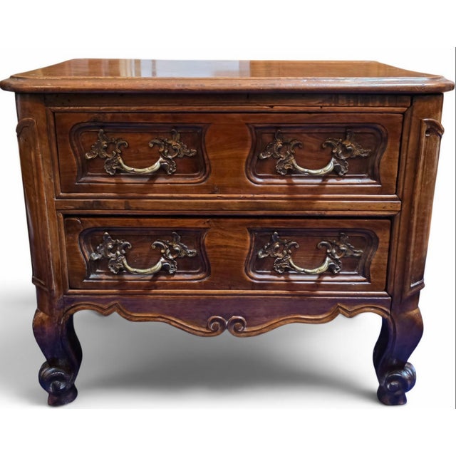 A charming early 19th-century French Provincial Louis XV petite commode, handcrafted in richly figured walnut and dating...