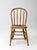 This antique American Windsor chair dates to the late 19th century and features a continuous bow back, turned spindles, a...