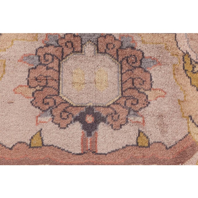 An early 20th century home inspired by Indian rug, the abrashed creamy pink field with a pendant medallions, palmette and...