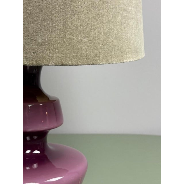 A striking Belgian mid-century table lamp featuring a sculptural, mouth-blown opaline glass base in a rich, deep purple...