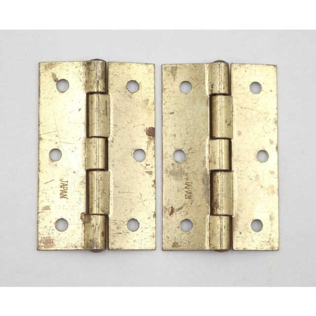 Vintage cabinet door hinges made of polished brass plated steel with flat tips, five knuckles, and a template hole...