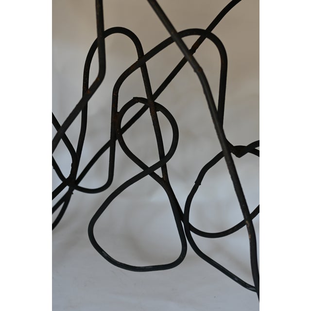 Imported from Belgium, this striking vintage console is defined by its sculptural squiggle iron base with an organic,...