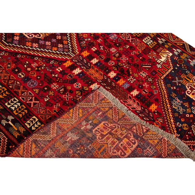 Beautiful Vintage Shiraz hand-knotted Wool rug with the red field. This Shiraz rug has a multicolor accents in all over...