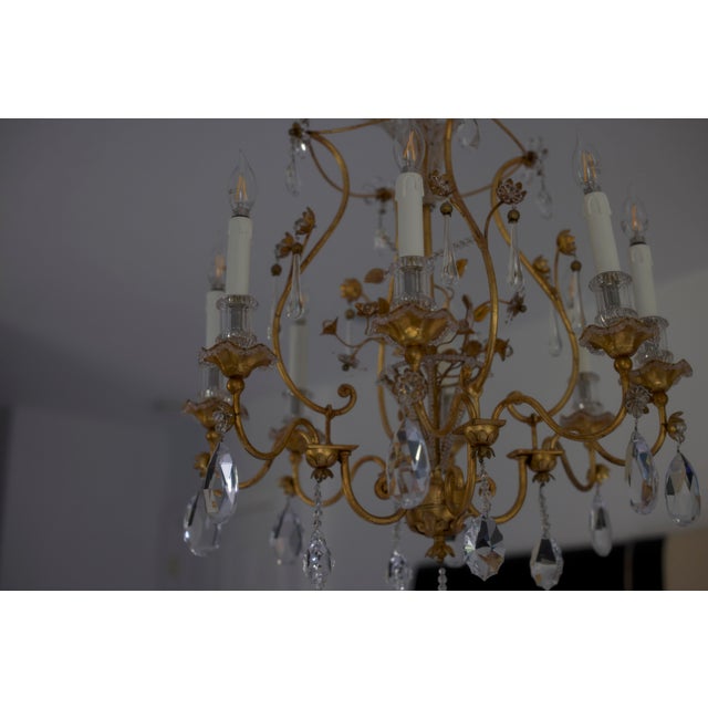 Exquisite vintage chandelier by Maison Baguès, featuring the house’s signature blend of gilded metal and sparkling crystal...